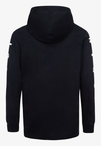 Haut à capuche noir avec des manches longues, une grande capuche et des lettres blanches sur les manches. Tissu doux avec une coupe décontractée.