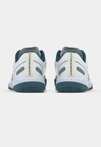 Fehér sportcipők türkizkék részletekkel és szürke elemekkel. Texturált felsőrész, párnázott szegély és barázdált gumitalp a jobb tapadásért.