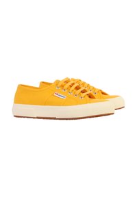 Sneakers gialli in tela con sei occhielli, suola in gomma bianca, punta testurizzata e branding laterale in rosso e bianco. I lacci sono dello stesso giallo.