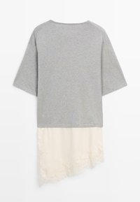 Jasnoszary top z krótkim rękawem z asymetrycznym dołem, który przechodzi w kremową koronkę na dole.
