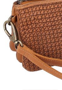 Brun læderhandbag med et struktureret diamantmønster, der har en messingklip og rem. Designet inkluderer en lynlåsåbning i toppen og en afrundet bund.