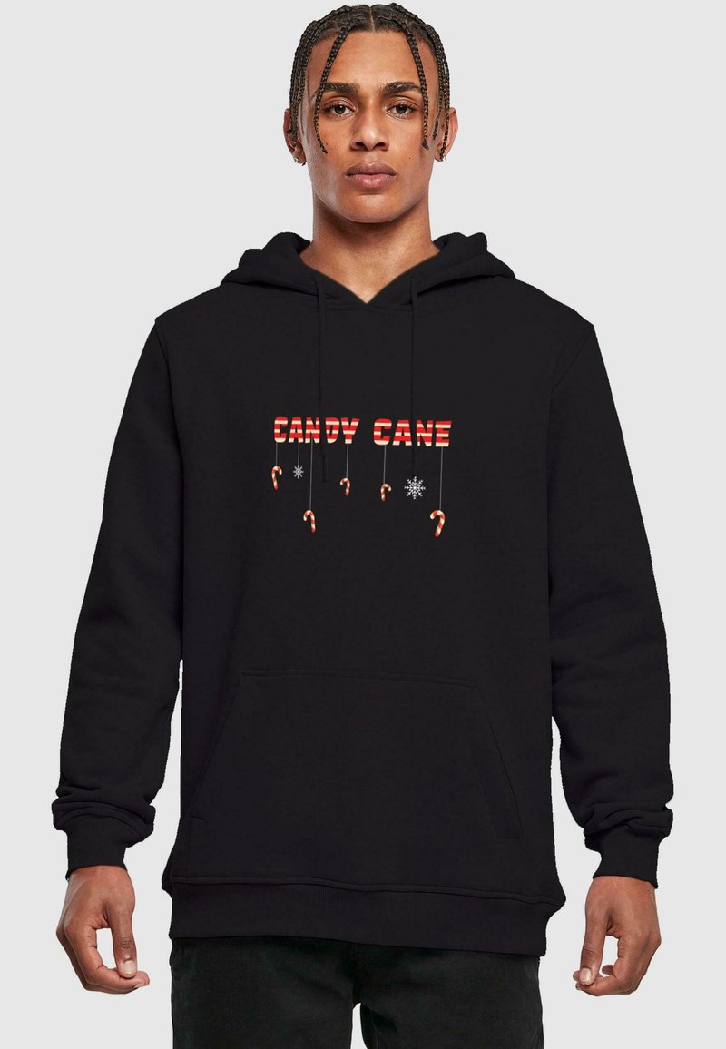 Čierna mikina s kapucňou s nápisom "CANDY CANE" v červených a bielych pruhovaných písmenách, so grafikou cukrovej palice a snehovými vločkami nižšie, s predným klokankovým vreckom.