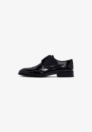 Chaussure oxford en cuir verni noir avec une finition lisse et brillante, dotée d'un bout arrondi, d'un laçage à l'avant et d'un petit talon empilé.