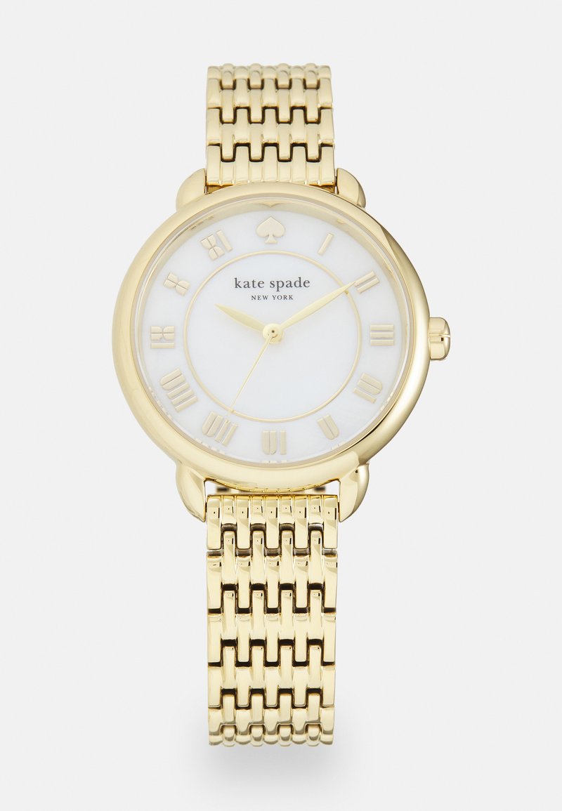 Gouden metalen horloge met een witte wijzerplaat, Romeinse cijfers en een klavertje vier-logo. Het horloge heeft een gevlochten band in armband-stijl en een ronde kast.