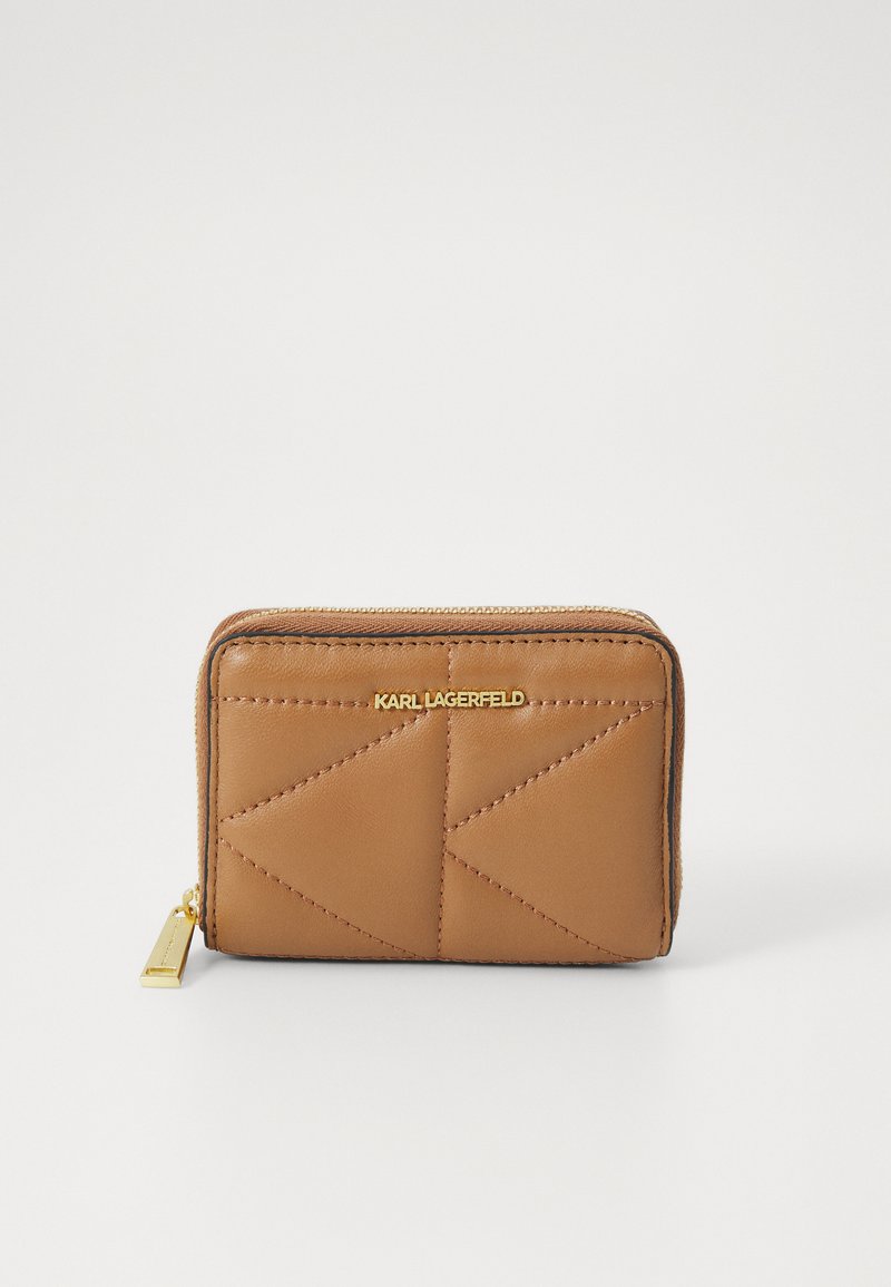 Portefeuille en cuir tan avec un design matelassé en triangles, matériel de fermeture éclair en or et logo en relief à l'avant, présentant une texture lisse.