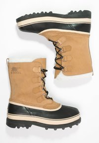 Brązowe wodoodporne buty z brązowej skóry na górze, czarną gumową dolną częścią, białym futerkiem wewnątrz i czarnymi sznurówkami. Rowkowana czarna podeszwa zapewniająca przyczepność.