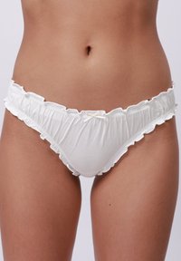 Witte katoenen bikini met een gegolfde rand, met een klein strikje aan de voorkant. De stof lijkt zacht en iets rekbaar.