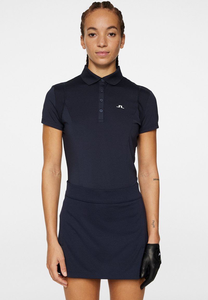 Robe de golf bleu marine avec un col polo, des manches courtes et une silhouette ajustée. Présente un design texturé et un petit logo sur la poitrine.