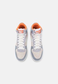 Sneaker alte con una tomaia in suede grigio chiaro e beige, lacci bianchi, dettagli arancioni e una punta perforata per una migliore traspirabilità.