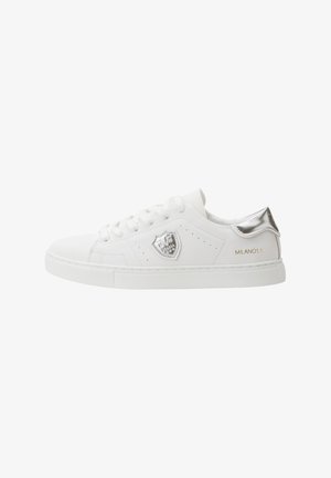 White leather sneaker with silver heel accent, logo patch, round toe, and perforated detailing. Features flat laces and a rubber sole.