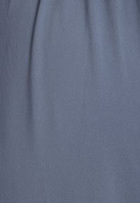 Blue fabric draped with a smooth texture, featuring subtle vertical ribbing. The material appears lightweight and flexible.