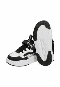 Baskets basses noires et blanches avec lacets et sangle velcro, motifs géométriques et semelle texturée vues de profil et de dessous.