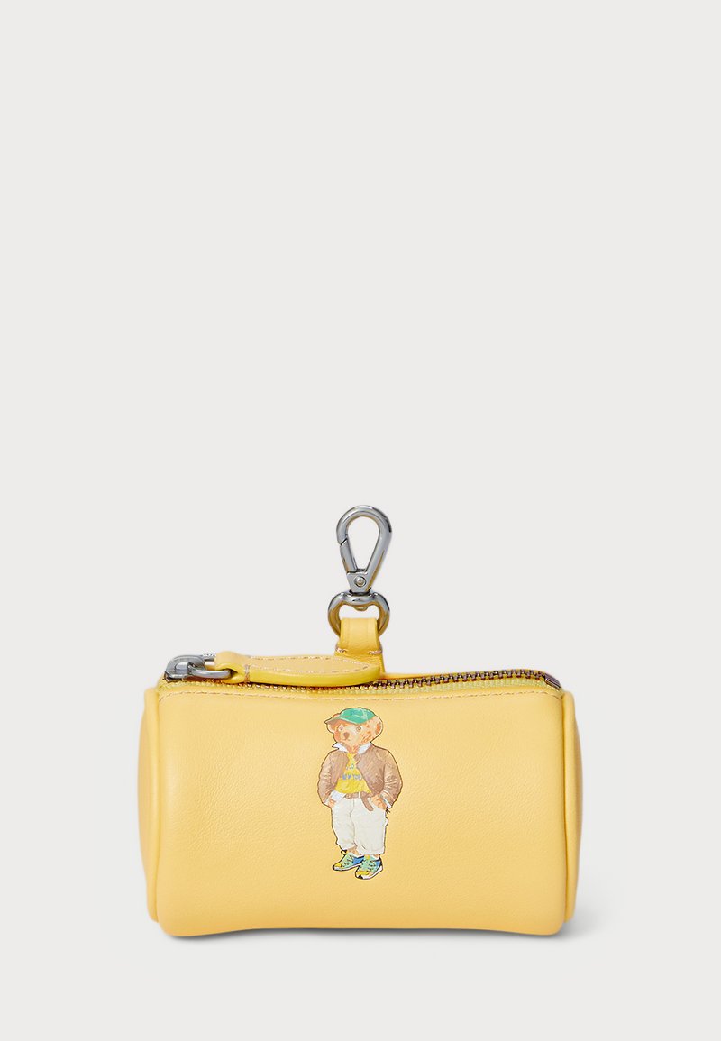 Yellow leather zip pouch with a silver hardware clip. Features an illustration of a bear wearing a brown jacket and green hat.