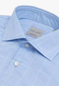 Camicia a quadri blu chiaro con colletto button-down, decorata con un'etichetta che recita "DAN JOHN REGULAR." Il tessuto presenta una sottile trama.