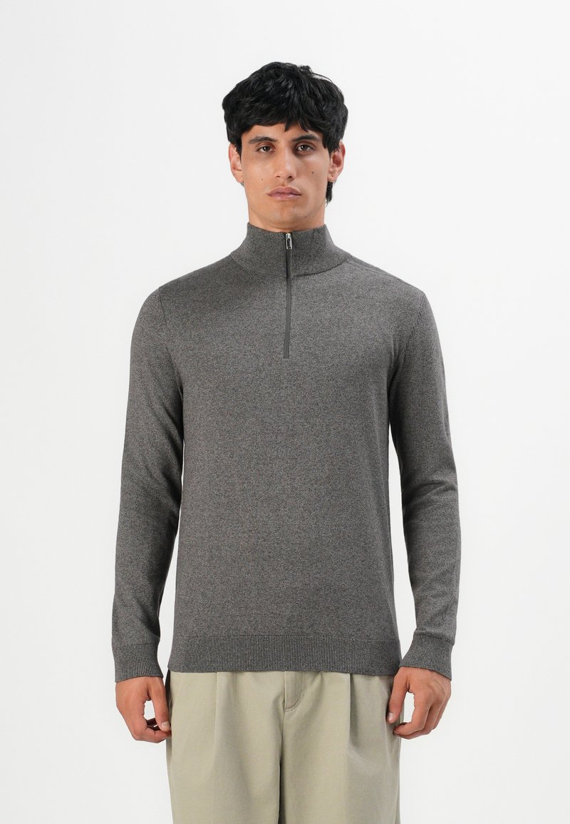 Pullover grigio a maniche lunghe con colletto alto e chiusura con zip. Realizzato in tessuto a maglia, presenta polsini e orlo a coste per un contrasto di texture.