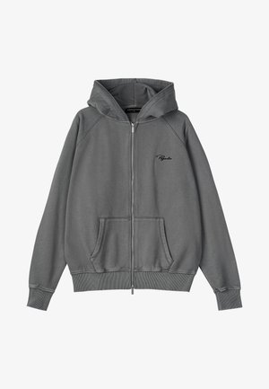 Zippana kapuca v sivi barvi s mehkimi teksturami. Ima kapuco z vrvico, kenguru žep, rebrastih manšetah in robu ter izvezeno logo.