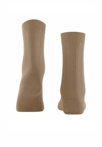 Beige Baumwollsocken mit geripptem Design, weicher Textur sowie verstärktem Fersen- und Zehenbereich. Besitzt vertikale Strickmuster an den Seiten.