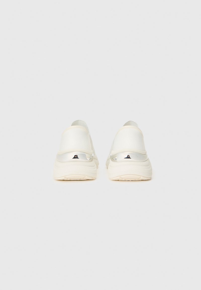 Białe sneakersy z teksturowaną cholewką, elastycznymi uchwytami na pięcie i amortyzowaną podeszwą. Posiadają srebrne akcenty na pięcie.
