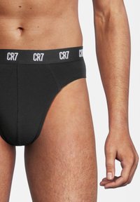 Slip neri con vita elastica alta e branding bianco "CR7". Texture liscia, design aderente e taglio su misura per il comfort.