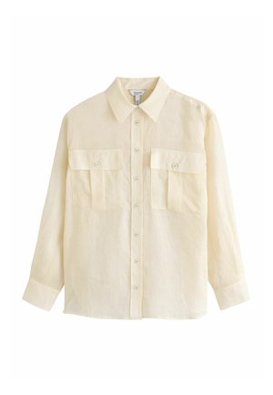 Langærmet beige skjorte med knapper, krave og to forlommer med knapper, vist på hvid baggrund.