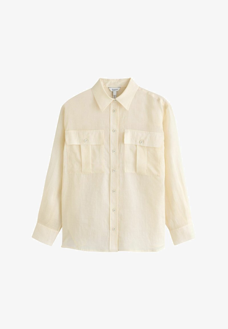 Chemise beige à manches longues avec boutons, col et deux poches à rabat boutonnées sur le devant, présentée sur fond blanc.