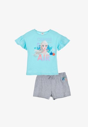 Camiseta de manga corta de color azul claro con un gráfico de un personaje, combinada con pantalones cortos grises que presentan un emblema colorido en el costado.