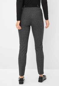 Charcoalgrijs, geweven stoffen broek met een getailleerd ontwerp, taps toelopende pijpen en een vlakke tailleband. Bevat een elastische achterkant en riemlussen.