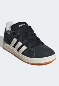Basket en suède noir avec des rayures latérales en cuir blanc, lacets noirs et semelle en caoutchouc texturé. Comprend une languette rembourrée et un logo.