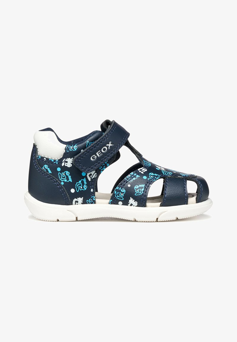 Sandale pour tout-petit bleu marine avec semelle blanche, bride à Velcro, orteil ouvert, et motif de robot bleu clair et blanc sur le dessus.
