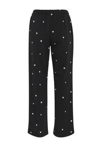 Schwarze weit geschnittene Hose mit kleinen weißen Herzmustern und einem elastischen Bund.