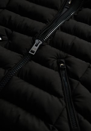 Chaleco acolchado negro con diseño acolchado, cierres de cremallera brillantes y una textura suave. Los detalles con cremallera y el acabado de tela suave mejoran la durabilidad.