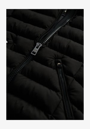 Zwarte gewatteerde vest met een gequilt ontwerp, glanzende ritsen en een zachte textuur. Ritsdetails en een gladde stofafwerking verbeteren de duurzaamheid.