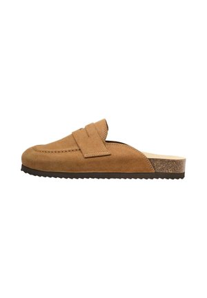 Mocassin à enfiler en suède marron avec semelle en caoutchouc plate et talon à texture liège, présentant un détail de bride sur le dessus.