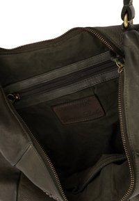 Wnętrze ciemnozielonej skórzanej torby, z kieszenią na zamek błyskawiczny oraz skórzaną metką z napisem "Venezia Genuine Leather". Miękka faktura. Zamek błyskawiczny.