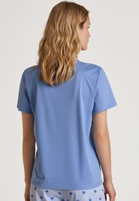 Korte mouwen blauwe T-shirt met een gladde textuur, ronde halslijn en een ontspannen pasvorm. Geen zichtbare patronen of accenten.