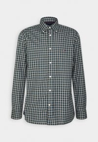 Camisa de cuadros de manga larga en azul oscuro, verde y beige. Parte frontal con botones, cuello y un pequeño detalle de logo en el pecho. Textura de tela de algodón.
