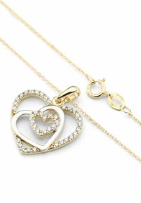 Collar con colgante de corazón dorado que presenta dos corazones entrelazados; uno bordeado con piedras claras brillantes. Incluye una cadena fina de oro con cierre.