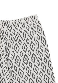 Tissu à motifs noir et blanc, avec un design en diamants et en zigzags. Matériau texturé avec une légère finition côtelée, léger et flexible.