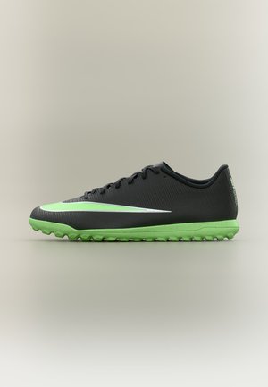 Schwarzer und grüner Fußballschuh mit strukturierter Sohle und grünem Swoosh-Logo an der Seite, im Profil auf neutralem Hintergrund gezeigt.