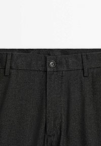 Pantalon gris foncé avec taille à fermeture par bouton et passants pour ceinture, avec un motif discret en chevrons sur le tissu.