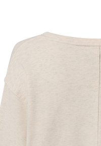 Jasnobeżowy top wykonany z teksturowanej tkaniny, z zaokrąglonym dekoltem i delikatnymi przeszyciami na ramionach. Z tyłu widoczna szew, bez wzorów i ozdób.