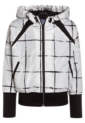 Veste blanche à capuche avec lignes de grille noires, accents noirs aux épaules, fermeture éclair frontale, poches latérales et poignets et ourlet noirs côtelés.