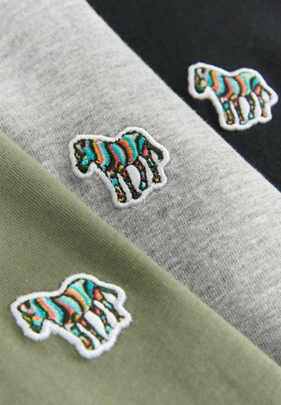 Tre capi di abbigliamento in cotone nei colori oliva, grigio e nero, caratterizzati da colorati ricami di zebre su ciascun pezzo.
