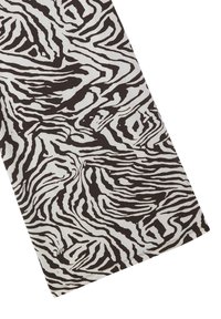 Tessuto a stampa zebra bianco e nero, con linee ondulate e una texture morbida, dalla forma rettangolare e bordi puliti.