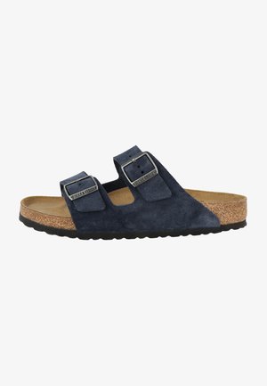 Sandalo scivoloso in suede blu navy con due cinturini regolabili dotati di fibbie in tono argento e una soletta in sughero, montato su una suola in gomma nera.