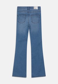 Bakifrån vy av blå denim flare jeans med två bakfickor och en vit märkesetikett på midjebandet mot en vit bakgrund.