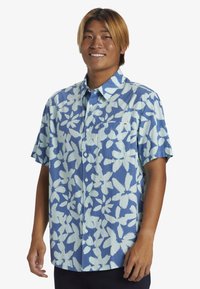 Camicia a maniche corte con bottoni di colore blu, decorata con un ampio motivo floreale blu chiaro, dotata di taschino sul petto e vestibilità comoda.
