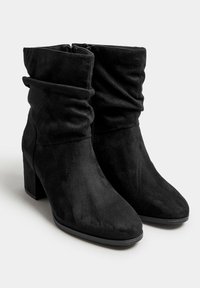 Botas de tobillo de ante negro con un diseño arrugado, punta cuadrada y tacón de bloque. Cuenta con una cremallera lateral para facilitar su uso.