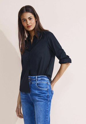 Zwart, lange mouwen overhemd met knopen en kraag, slim fit. Gecombineerd met lichtblauwe denim jeans met een klassieke vijf-pocket ontwerp.