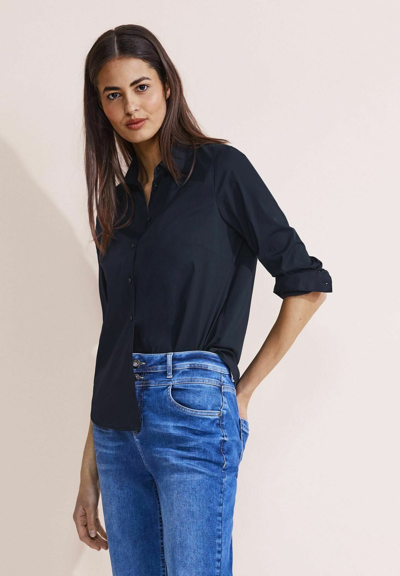 Zwart, lange mouwen overhemd met knopen en kraag, slim fit. Gecombineerd met lichtblauwe denim jeans met een klassieke vijf-pocket ontwerp.